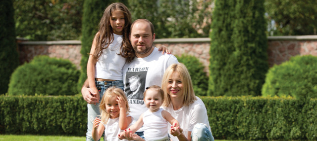 Вадим Столар з дружиною Інною Майструк та дітьми на фоні муру довкола родинного маєтку